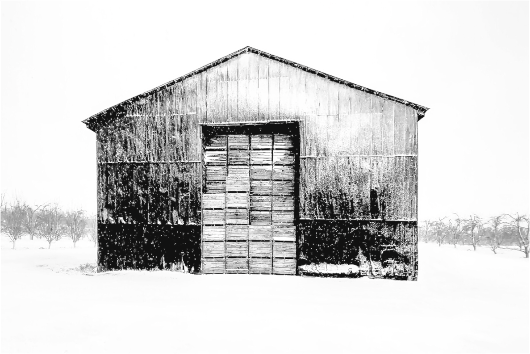 Black and white photograph of a barn against open sky—minimalist rural scene evoking simplicity, memory, and architectural stillness.