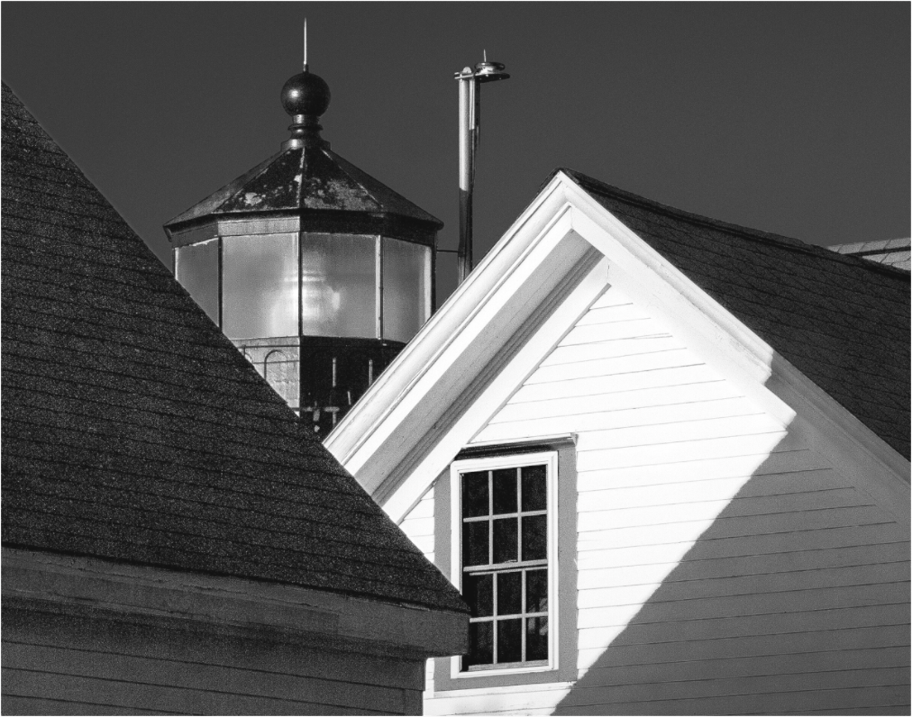 Black and white photograph of a barn or farmhouse with high-contrast lighting—minimal composition emphasizing structure and luminance.
