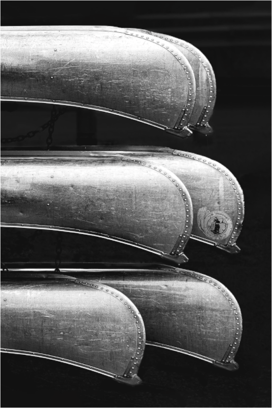 Black and white photograph of rental boats in parallel rows—minimalist composition evoking repetition, rest, and visual harmony.
